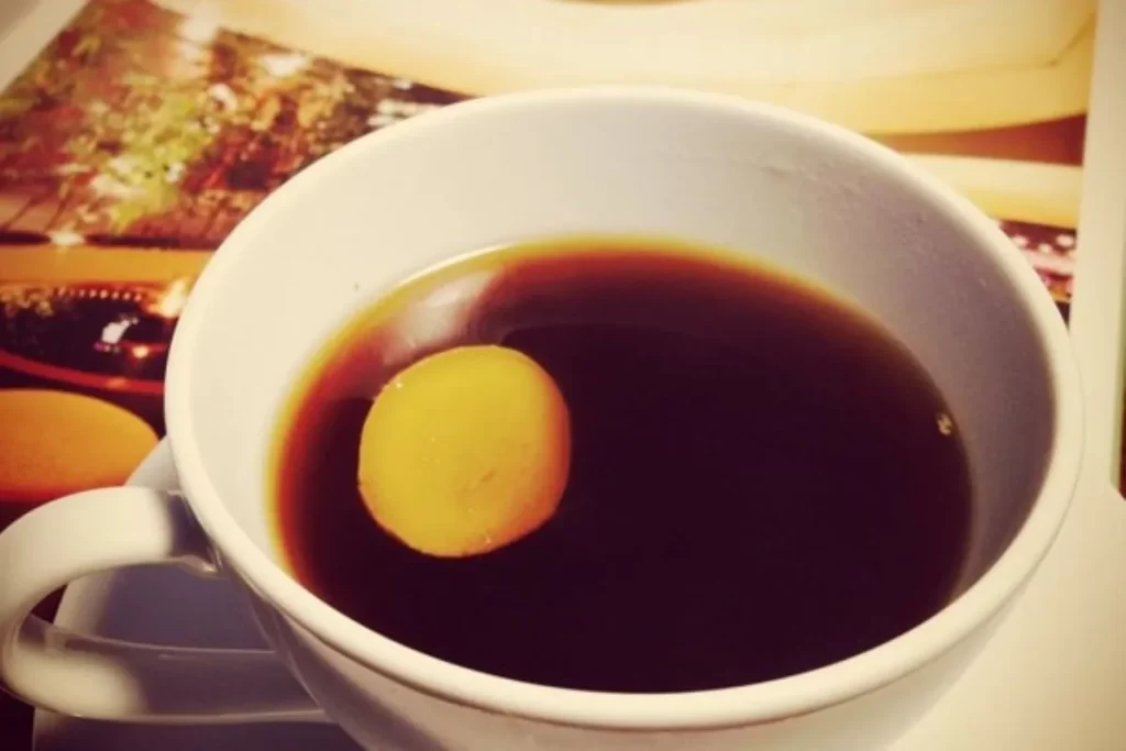 黒糖生姜湯の完成イメージ、白いカップに生姜スライスが浮かんだ温かい飲み物で冷え性改善に最適