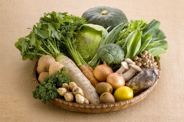 木のザルに盛られた新鮮なオーガニック野菜の集合