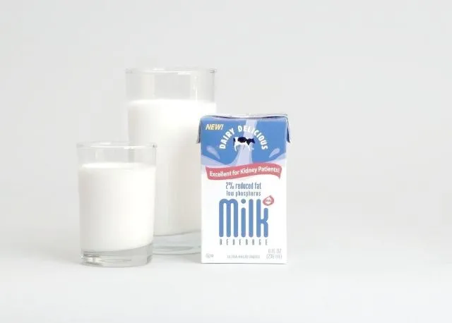牛乳のコップ2つと牛乳パック。尿路結石の原因になりやすい牛乳