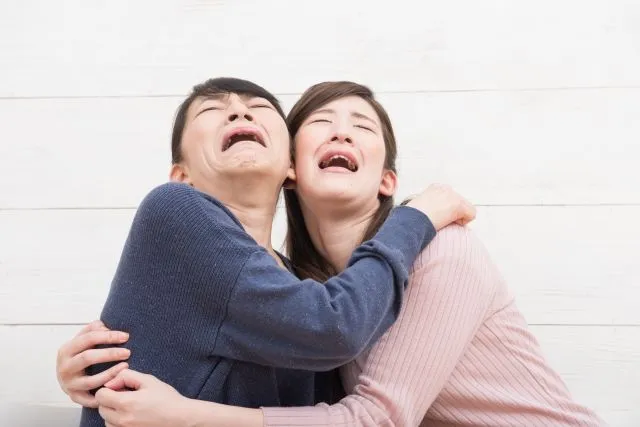 健康診断の良性結果を聞いて抱き合って泣く2人の女性のイラスト