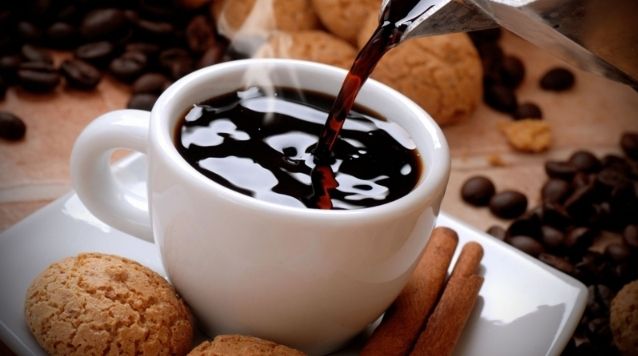 白いコップに注がれたブラックコーヒーと、その隣に置かれたクッキー。中医学ではコーヒーの過度な摂取が脾臓や胃腸を冷やし、月経随伴性気胸の悪化要因となる可能性がある。
