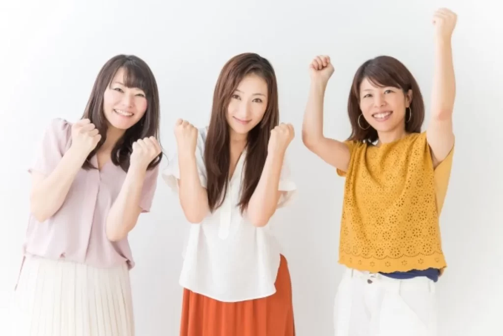 回復を喜ぶ3人の女性が笑顔でガッツポーズしている写真