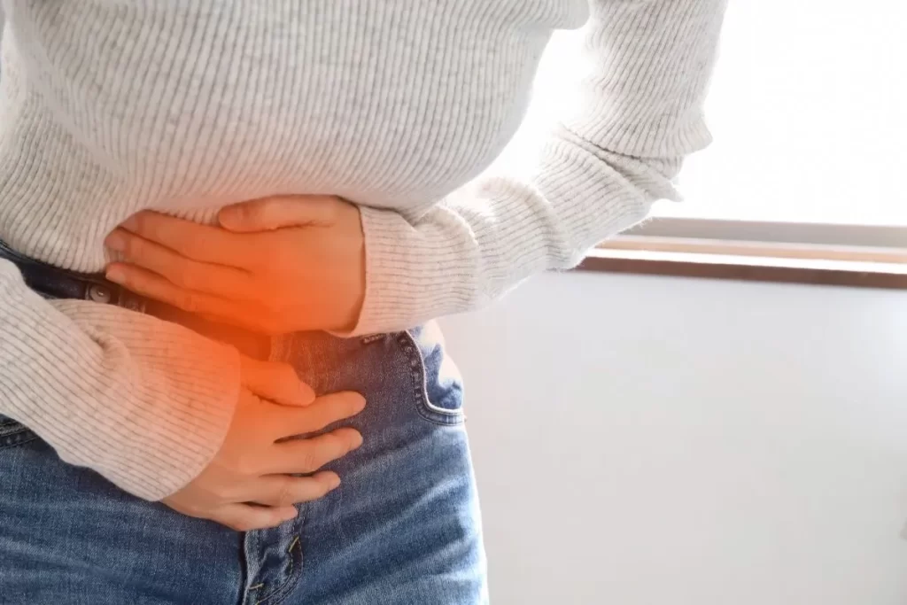 生理痛でお腹を押さえて前屈みになる女性のクローズアップ