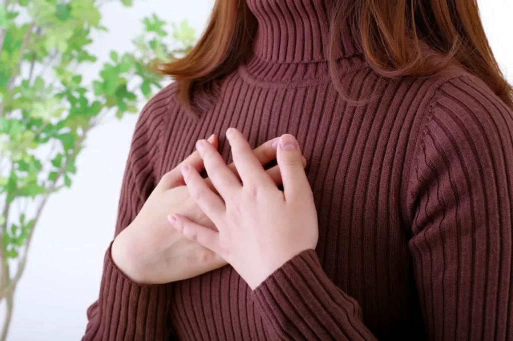 乳がんのしこりに不安を抱える女性が胸を押さえているイメージ