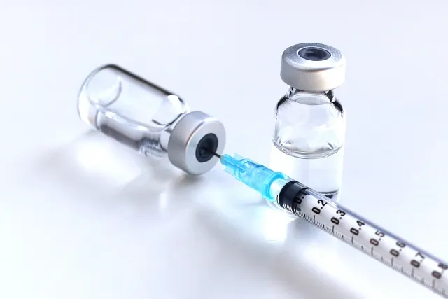 薬瓶から薬液を吸い上げる注射器のイメージ