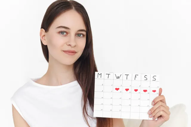 白人女性が月経カレンダー(生理周期トラッカー)を持っている画像