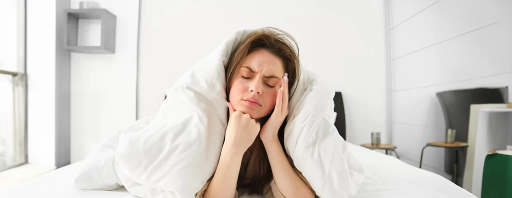 肩と膝の手術後、両手の腫れと痛みで眠れず苦しむ女性のイメージ