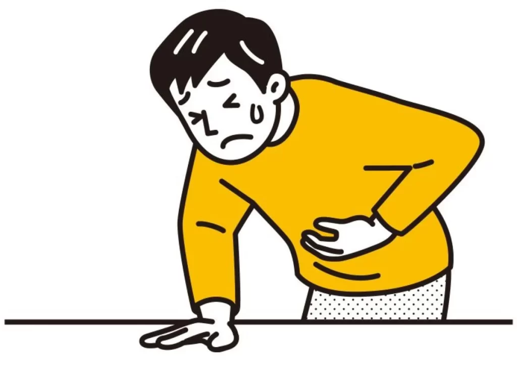 急な胃痛で苦しむ男性の漫画イラスト。お腹を抱え全身の脱力感を表した表情で、青い汗が浮かんでいる