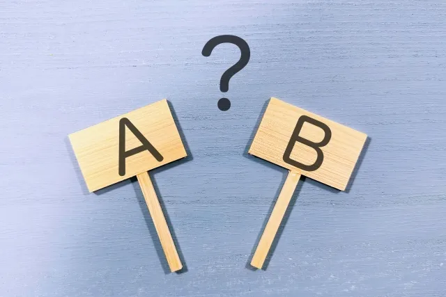 AとBの選択肢を示す2枚のプラカードを持つイメージ図