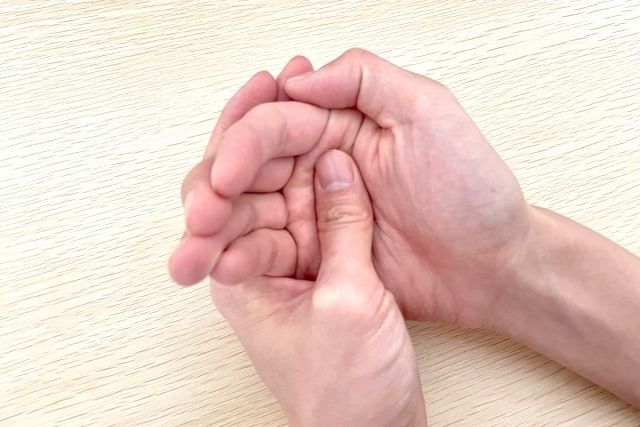 漢方治療で改善した糖尿病患者の手元と木彫のバック