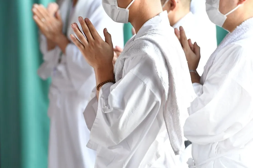 西洋医学を盲信する大勢の人々、白衣の信者たちが跪く様子