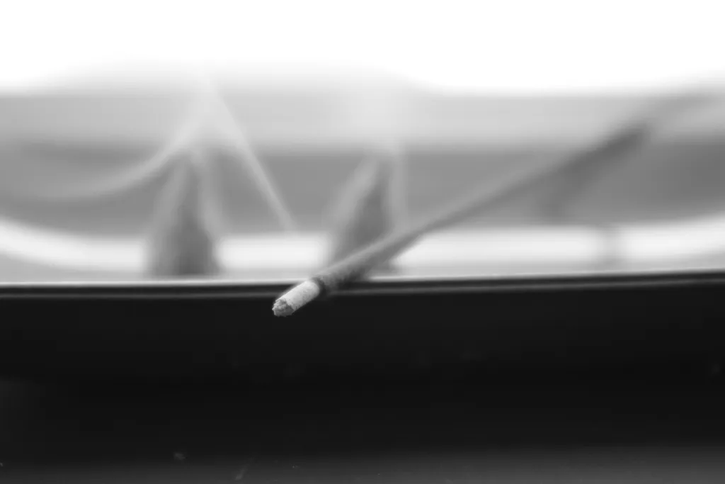 ステンレス皿に乗った円錐艾からモクモクと煙が上がるお灸