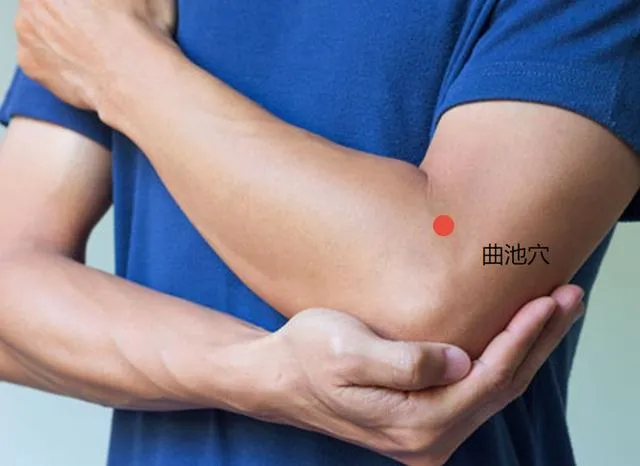 曲池穴の位置図（左肘を曲げて赤丸表示、青い半袖男性モデル）