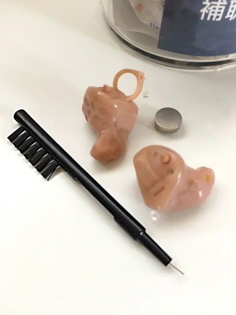 補聴器と掃除用ブラシが並べられた写真