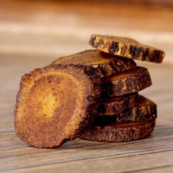 炙甘草（しゃかんぞう）の根を輪切りにしたスライスが複数重なって並んだ芸術的な生薬画像