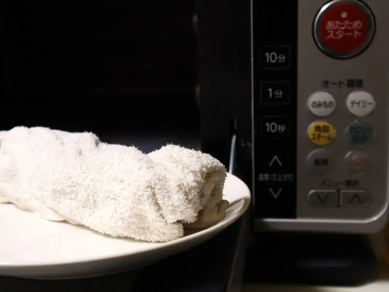 電子レンジで温めた蒸しタオルが白い皿に置かれている写真