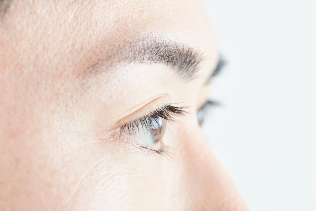 男性の右目を横から撮影したクローズアップ画像。まぶたがピクピクする症状を表現。