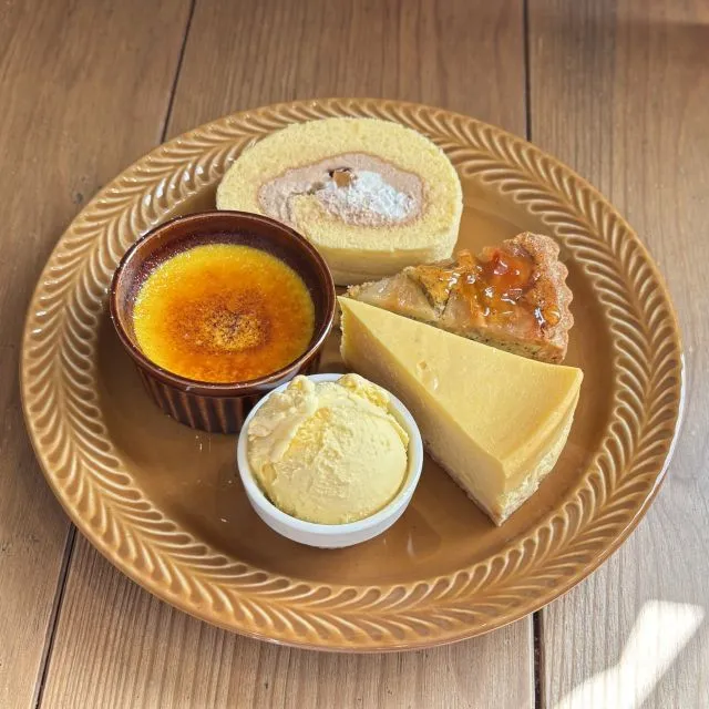 乳製品の盛り合わせ：アイスクリーム、チーズケーキ、ロールケーキ、ヨーグルトなどが円型容器に並んだ画像