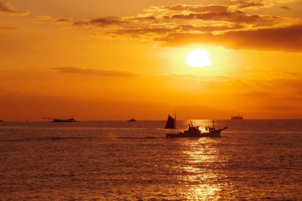 海に沈む夕日と船のシルエット