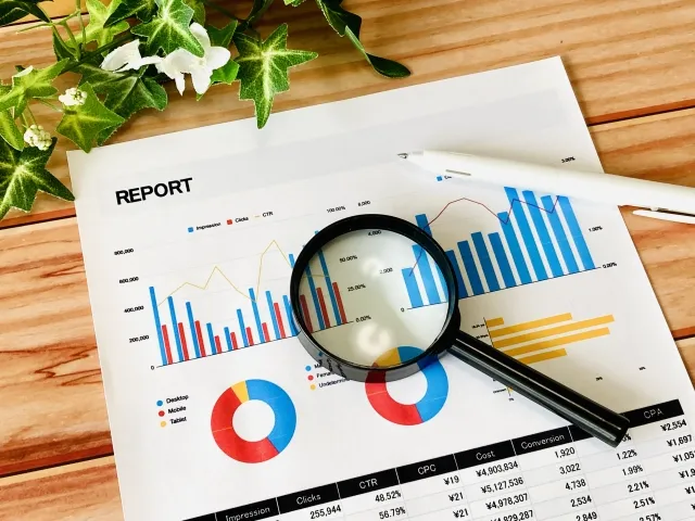 REPORTと書かれたグラフチャートに虫眼鏡とペンが置かれているイラスト。西洋医学の統計データの限界を象徴