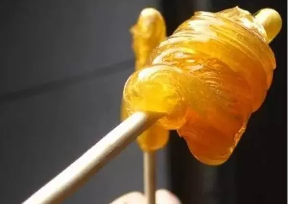 箸に巻かれた黄色い麦芽糖の漢方薬