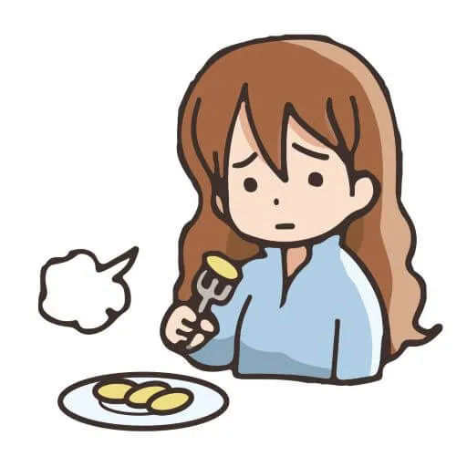 食欲がなくフォークで食べ物を刺してため息をつく女の子