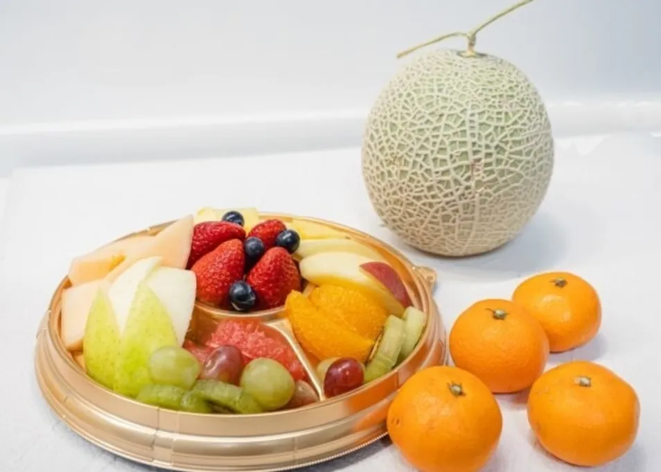 いちご・りんご・ぶドウなどが山盛りの果物皿とメロン・みかん