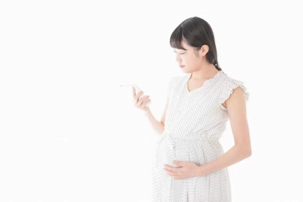 妊娠中にスマートフォンでプロゲステロンやhCGの検査値を確認する女性