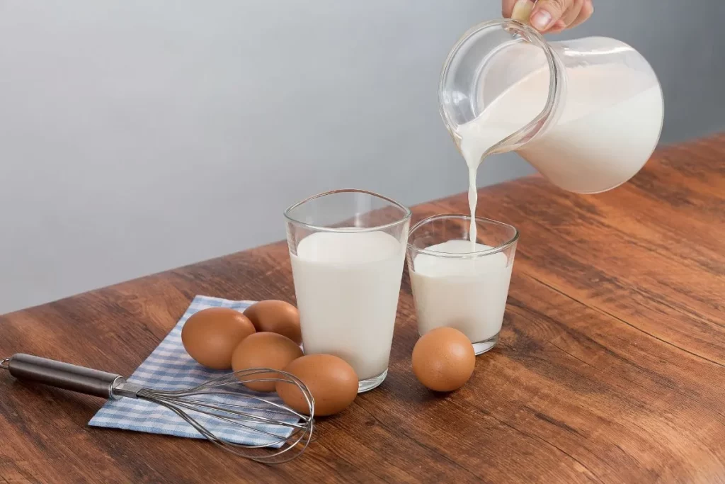 牛乳をコップに注ぐ様子と卵が並んだ写真