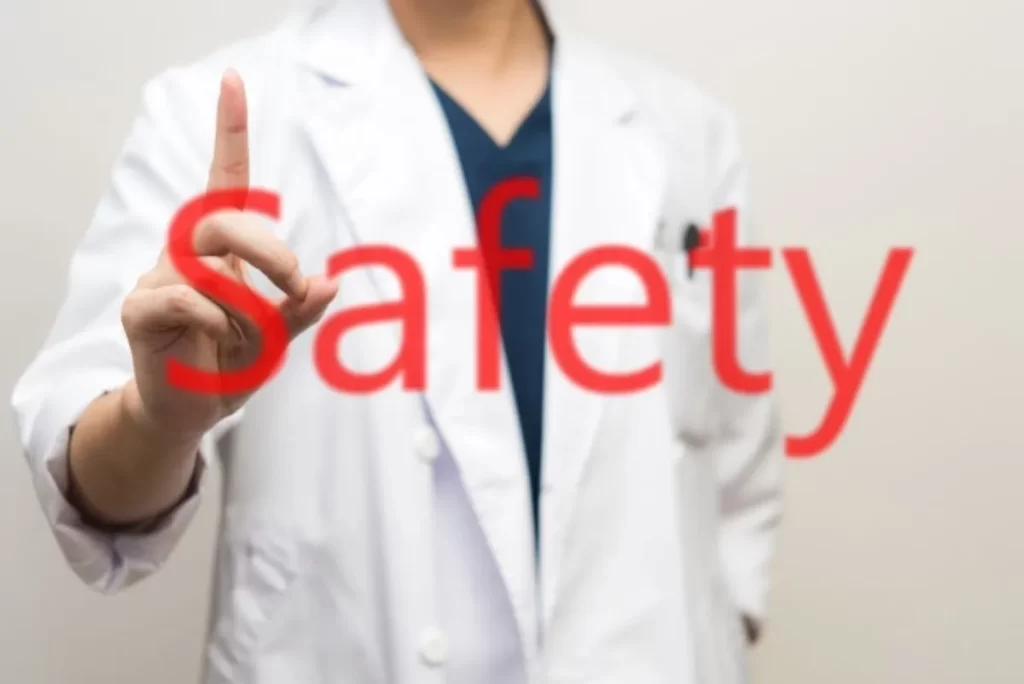 安全性を示すように指を立てる白衣の医師と「Safety」の文字