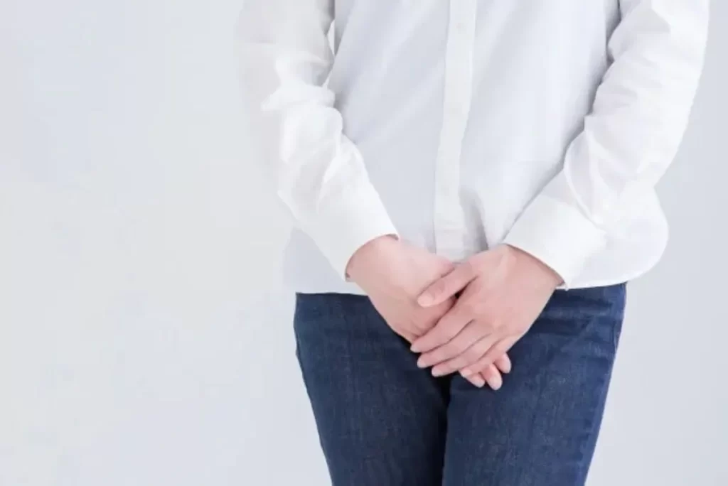 ジーパンを穿いた女性が両手でデリケートゾーンを隠している写真。陰部の乾燥をイメージした構図。