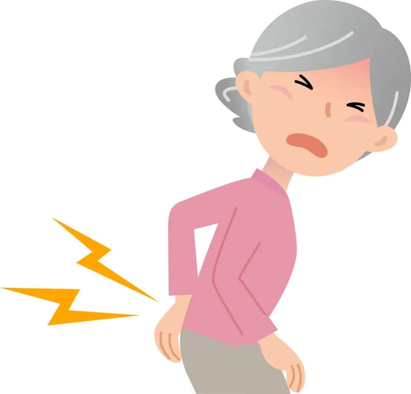 ピンク色の服を着たシニア女性がお尻の痛みを手で押さえる様子