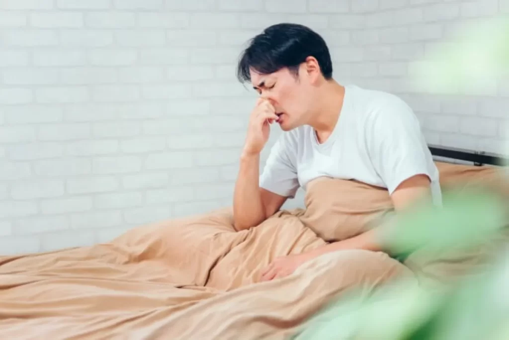 アレルギー性鼻炎で鼻水に悩み鼻をつまむ男性のイメージ