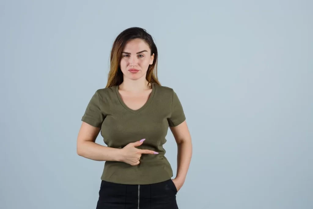 左肋骨の違和感を示すように指差し、苦しそうな表情をする白人女性