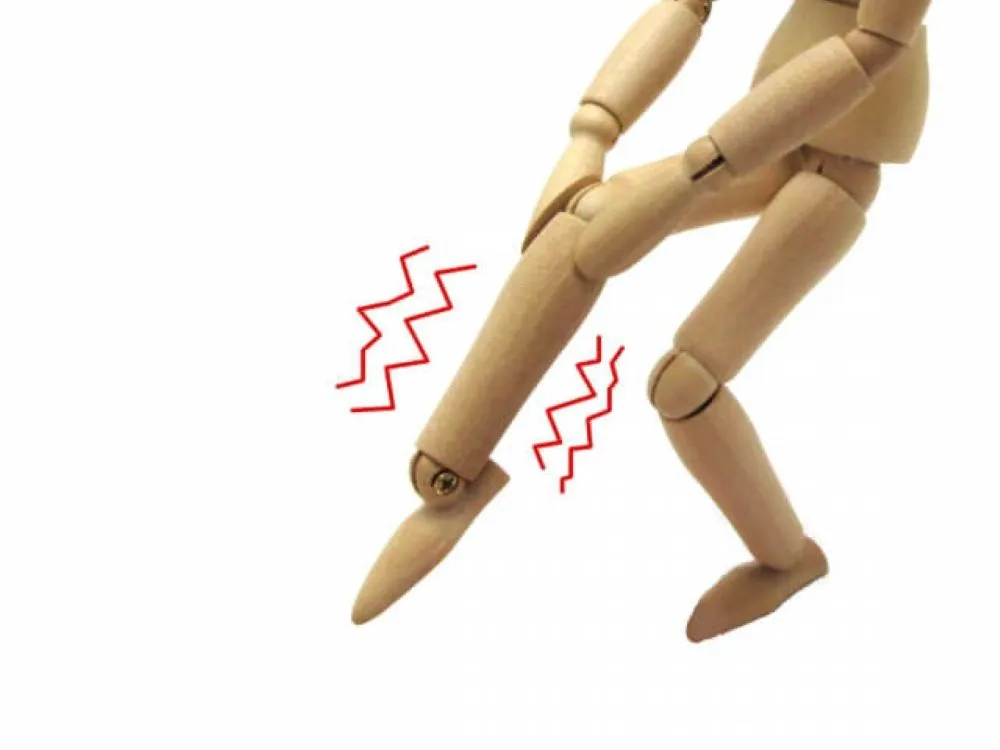 足のしびれを表現したイラスト。木製人形が右膝を押さえ、足に赤い波線が描かれている