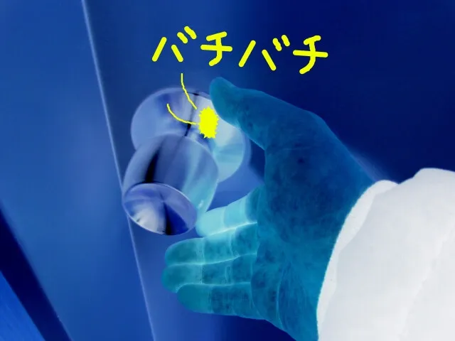 静電気体質の女性がドアノブを触るとパチパチと静電気が発生するレントゲン風イラスト