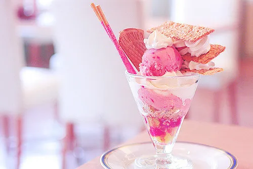 ピンクのアイスクリームにクリームとチョコ棒が2本乗ったデザート