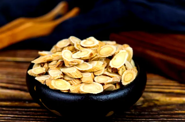 黒い皿に盛られた黄耆のスライス（漢方生薬）。補気・免疫向上作用で乳がん治療の処方に使用。