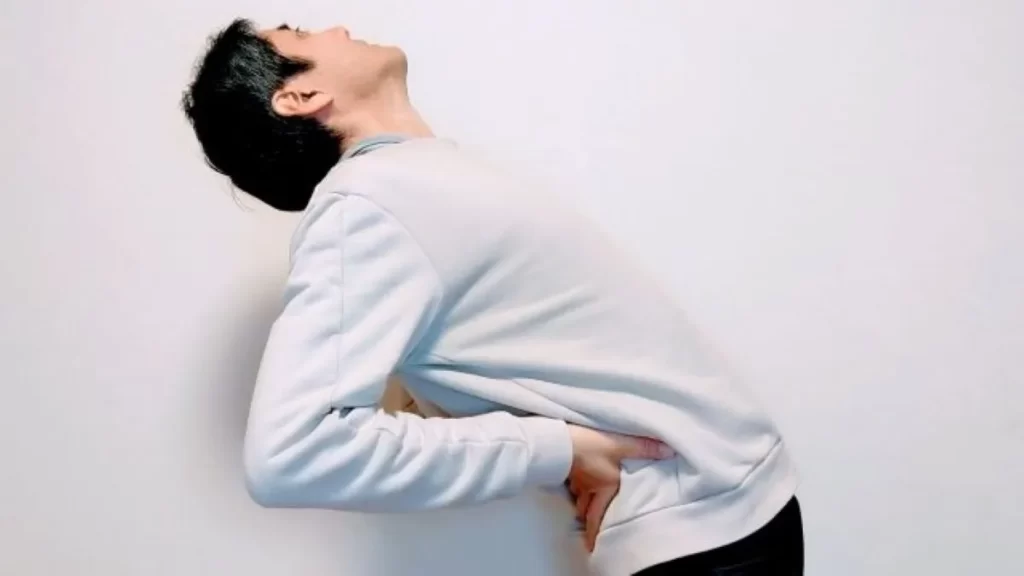 腰を後ろに反らして伸ばす男性の様子。寝起き時の腰痛をイメージしたイラストレーション。