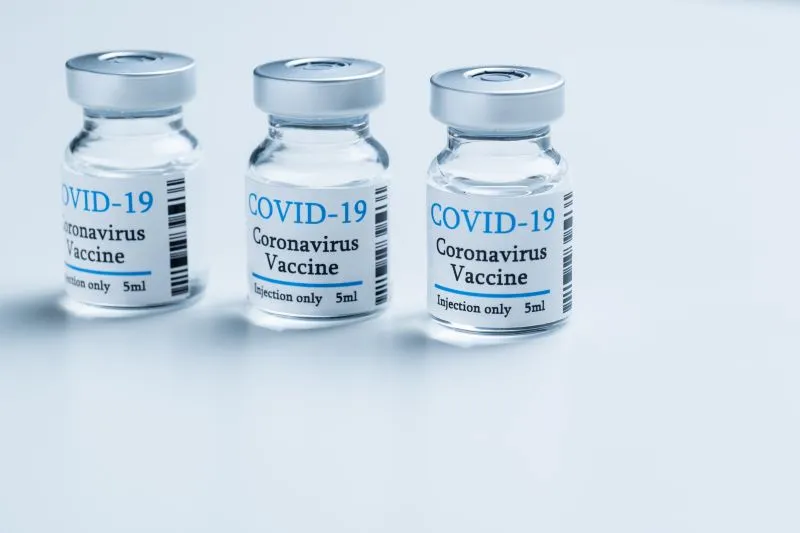 COVID-19と表示されたラベルの薬瓶が3本並ぶイメージ画像。