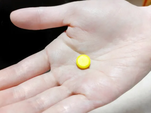 手のひらに黄色い1錠の薬が置かれているイメージ。メルカゾールを表す。