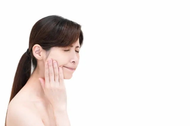 右の歯がしみる女性が目を瞑って触る様子を鍼治療で改善