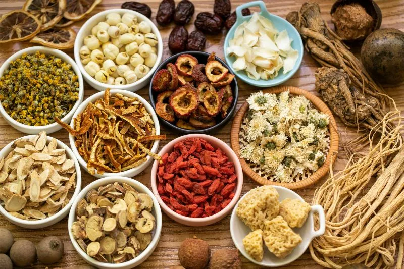 陶器の茶碗にきれいに並べられた様々な漢方生薬。上から見た煎じ薬の調剤風景。