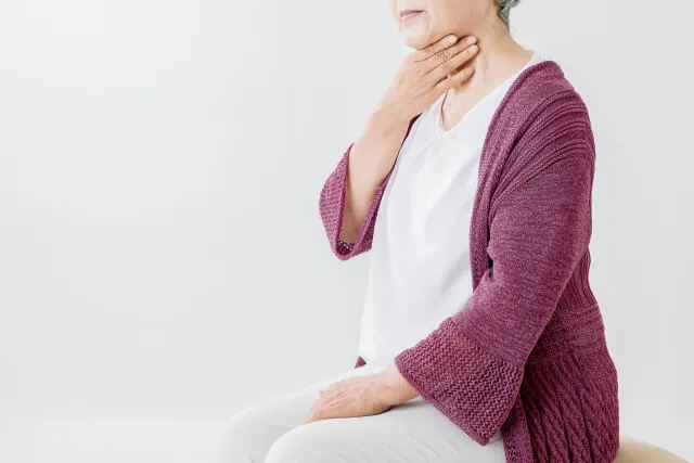 咳で喉を触るワインレッドセーターの女性。咳症状の不快感を表すイラストレーション。