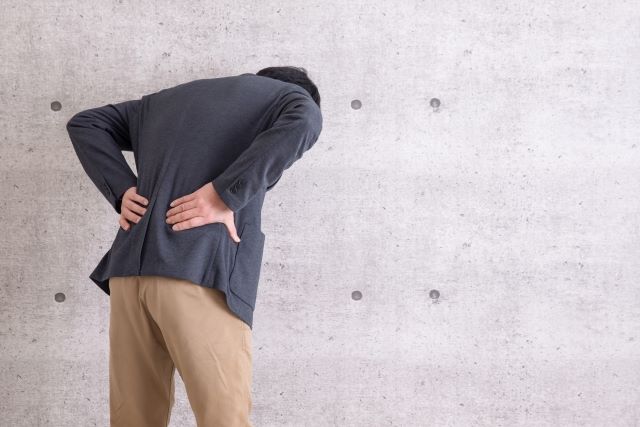 腎臓結石による腰痛で腰を抑える男性