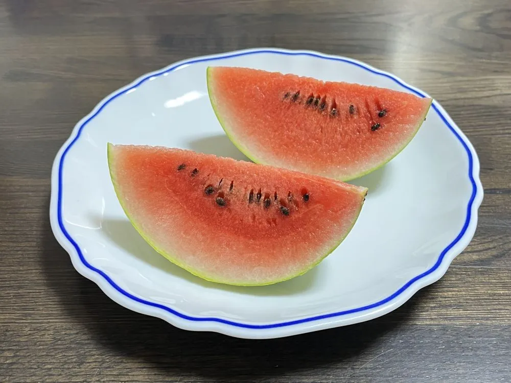 皿に盛り付けられた赤くてみずみずしいスイカの切り身が並んでいる画像
