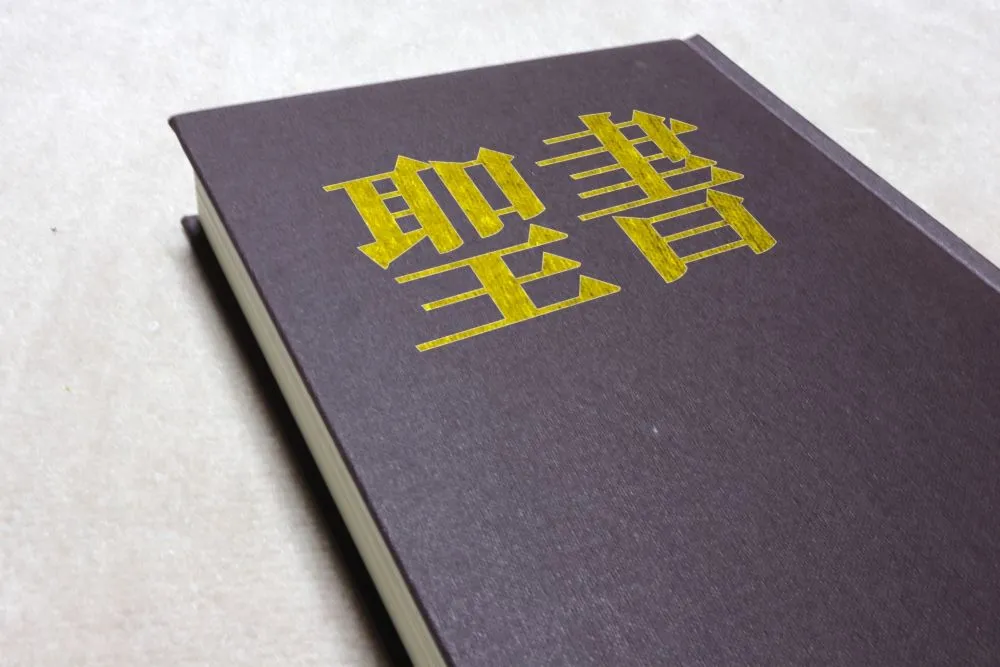 茶色の革装丁の本。表紙に黄色い文字で「聖書」と金文字で書かれている。