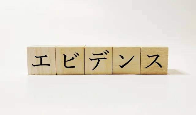 木製のブロックが並び、それぞれにエービーデーンースの文字が書かれたエビデンスを表すイメージ