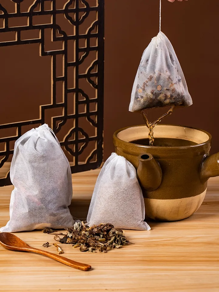 煎じ袋から滴る漢方薬の煎じ汁と、隣に置かれた2包の漢方薬