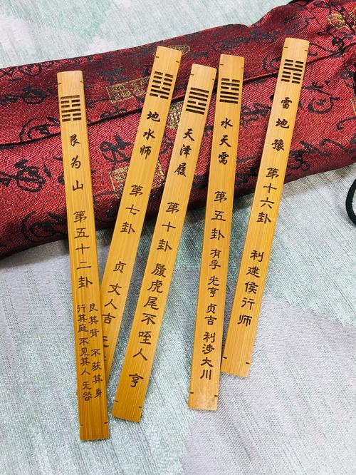 中国風絹背景の易経卦象と卦辞が書かれた細長い木板